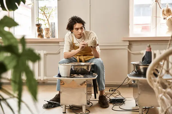 Stylish man shapes ceramics with focus in a pottery studio rich in artistic ambiance. — Stock Photo