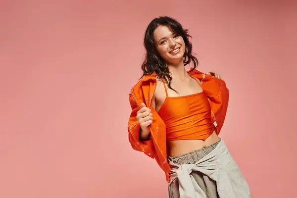 A young woman showcases her fashionable orange ensemble, radiating personality and charm. — Stock Photo