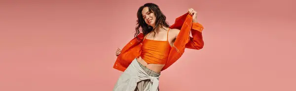 Young woman expresses her fashion sense with vibrant attire and playful poses in a cheerful setting. — Stock Photo