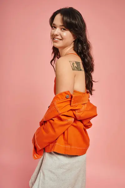A young woman in trendy clothing showcases her unique style with a cheerful attitude. — Stock Photo
