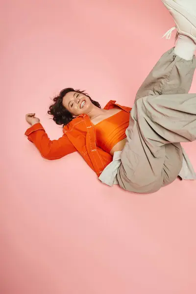 A young woman shows off her style against a vibrant pink background. — Stock Photo