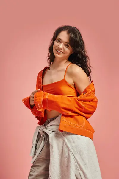 A young woman embraces her fashionable side, showcasing a bright outfit with a warm smile. — стоковое фото