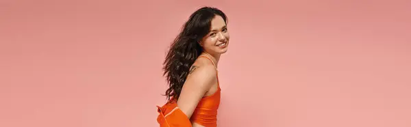 Una joven mujer muestra con confianza su aspecto elegante, sonriendo juguetonamente a la cámara. - foto de stock