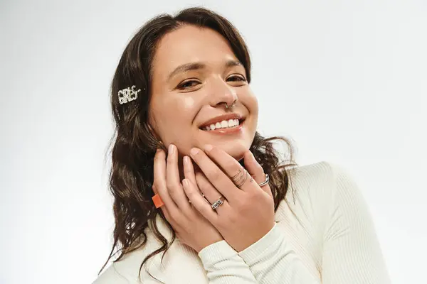 Una giovane donna irradia stile e bellezza mentre esprime gioia e fiducia in abbigliamento alla moda. — Foto stock