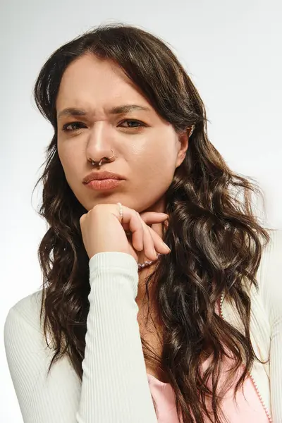 Mujer joven exhibe un comportamiento sorprendentemente elegante con una expresión reflexiva en casa. - foto de stock
