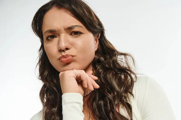 A fashionable woman with wavy hair strikes a fun pose while showing off her trendy outfit. — Stock Photo