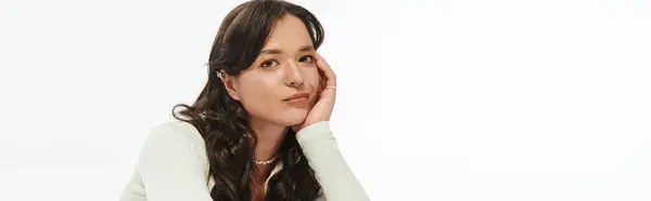 A stylish young woman poses thoughtfully against a light background. — Stock Photo