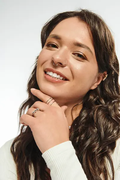Confident young woman smiles brightly while highlighting her fashionable style and accessories. — Stock Photo