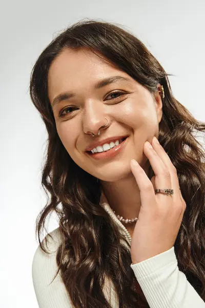 A young woman radiates charm and style, smiling warmly while posing gracefully indoors. — Stock Photo