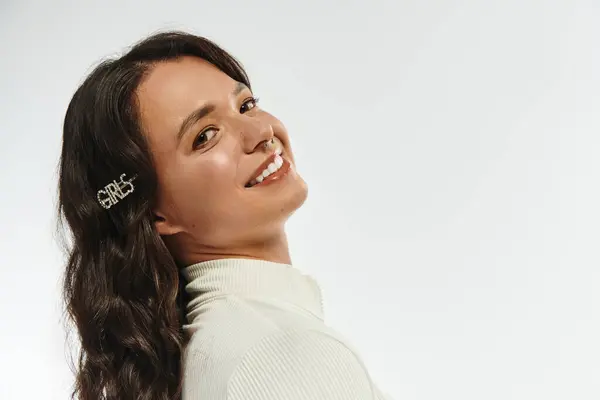 Fashionable young woman smiles brightly while posing gracefully with stylish hair accessories. — Stockfoto
