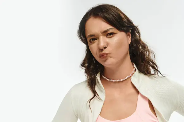 Una mujer joven con estilo emana confianza con una sonrisa encantadora en un entorno brillante. - foto de stock