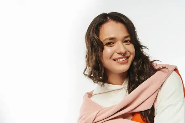 With a warm smile, a young woman showcases her chic style in a bright studio setting. — Stock Photo