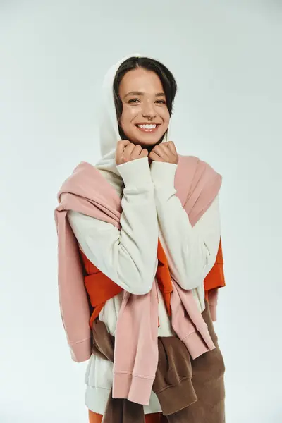 A young woman beams with joy, wrapped in trendy layers of stylish clothing. — Stock Photo