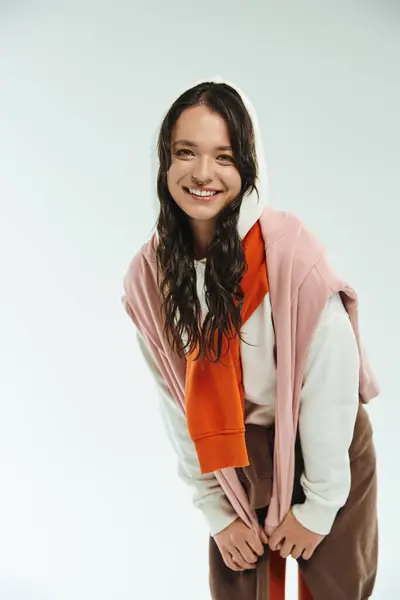 Una giovane donna modella alla moda con un sorriso allegro in un ambiente semplice. — Foto stock