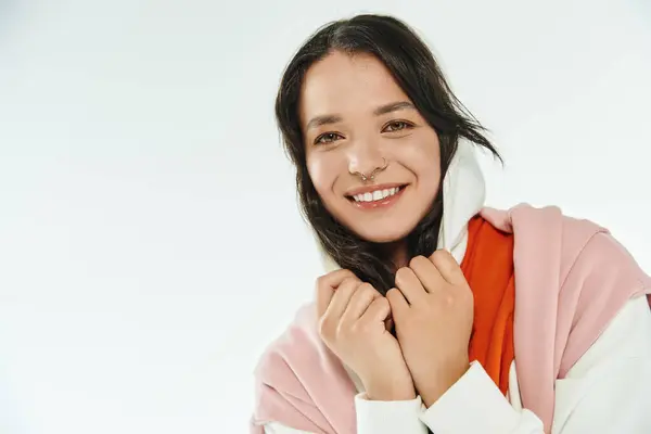 A fashionable young woman embraces her unique style while smiling warmly in a bright atmosphere. — Stock Photo