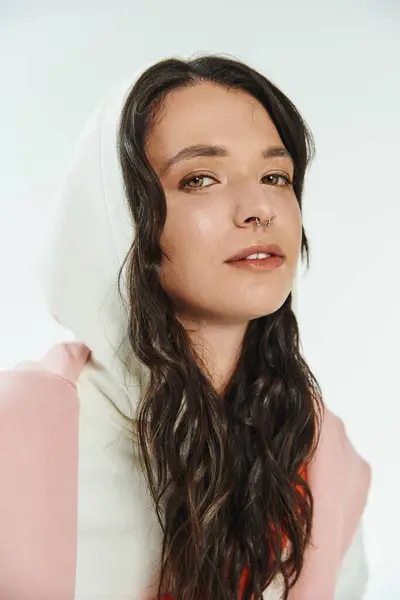 Young woman wears a fashionable outfit with a chic hoodie, radiating confidence and style. — Stock Photo