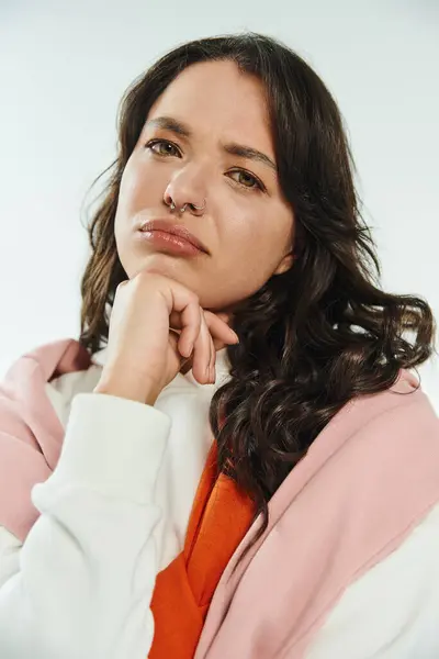 Contemplative young woman with beautiful features showcases trendy fashion in serene ambiance. — Stock Photo