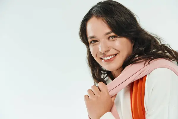 Giovane donna alla moda sorride radiosamente mentre mostra il suo abbigliamento elegante e fascino. — Foto stock