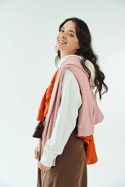 A young woman displays her unique style with layered clothing and a warm smile indoors. — Stock Photo