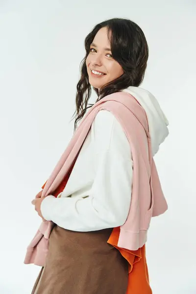 Young woman in fashionable attire smiles confidently while showing off her unique style. — Stock Photo