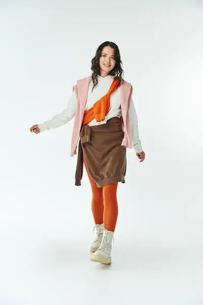 Elegante giovane donna che cammina con fiducia in un vestito chic, esprimendo le tendenze della moda moderna — Foto stock