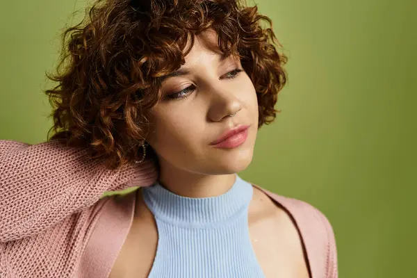A young woman showcases her chic summer style with curly hair on a bright green background. — Stock Photo