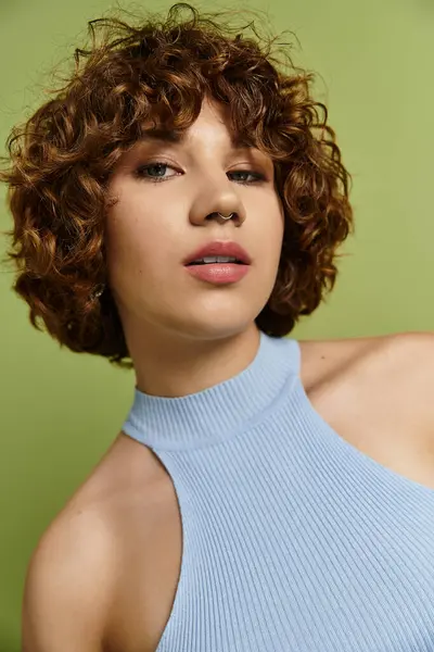 A young woman flaunts her trendy summer style with short curls against a green backdrop. — Stock Photo