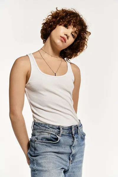 Una mujer joven en ropa casual de verano posa con confianza sobre un fondo blanco brillante. — Stock Photo
