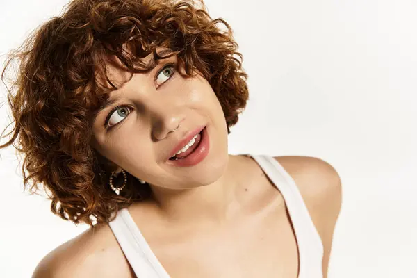 Una joven mujer emana confianza en una camiseta blanca sobre un fondo blanco crujiente. — Stock Photo