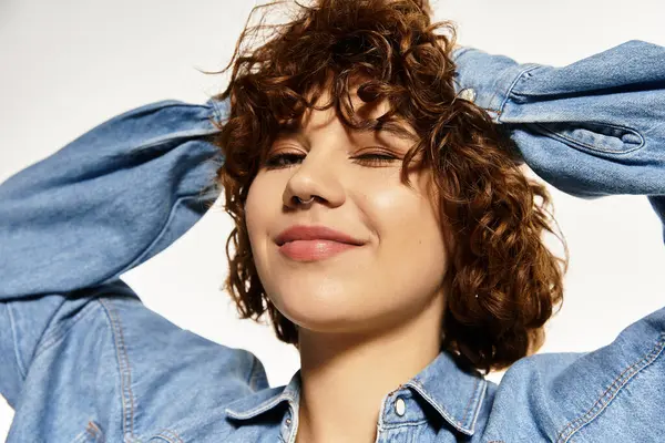 Una mujer joven con el pelo rizado corto posa con confianza en una camisa de mezclilla — Stock Photo