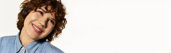 A young woman with short curly hair smiles warmly while dressed in a denim shirt, banner — Stock Photo