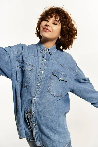 A confident young woman with short curly hair in a denim shirt and jeans, exuding summer vibes. — Stock Photo