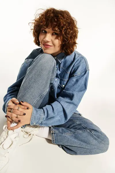 A young woman with curly hair poses confidently in denim attire, exuding summer vibes. — Stock Photo