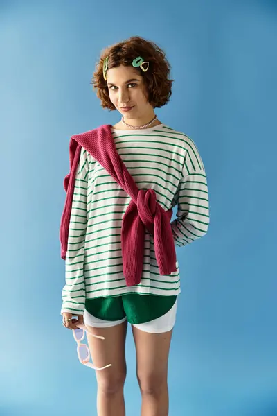 Young woman with short curly hair showcases her vibrant summer outfit in a playful pose. — Stock Photo