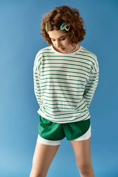 A young woman with short curly hair showcases a stylish vibrant outfit, posing confidently. — Stock Photo