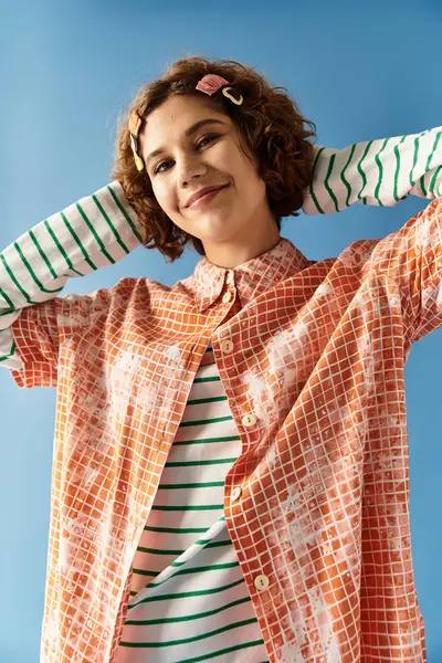 Young woman radiates confidence in a lively outfit against a bright blue background. — Stock Photo