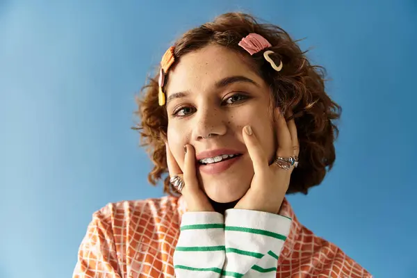 Cheerful young woman poses confidently with her curly hair and colorful attire. — Stock Photo