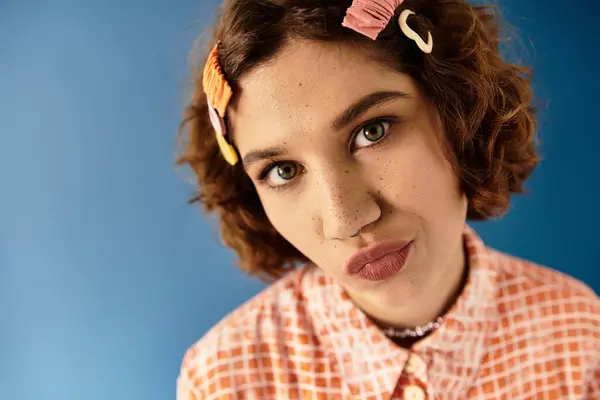 A confident young woman with short, curly hair poses in a vibrant outfit with hair clips. — Stock Photo