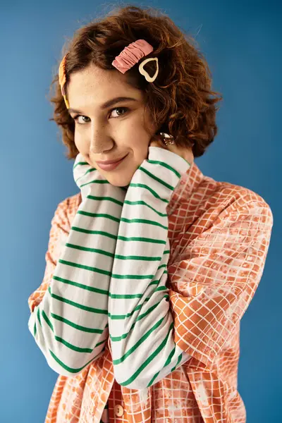 A young woman with short curly hair poses playfully in a vibrant summer outfit, smiling warmly. — Stock Photo