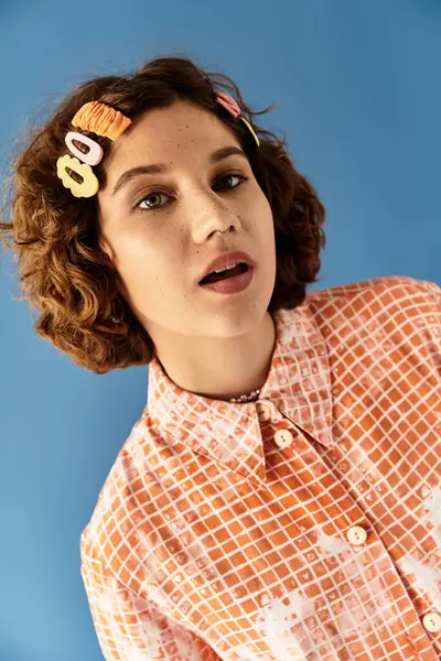 A young woman with short curly hair poses confidently in a colorful outfit, exuding summer vibes. — Stock Photo
