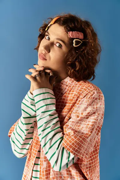 A stylish young woman with curly hair poses in a colorful outfit, exuding confidence and joy. — Stock Photo