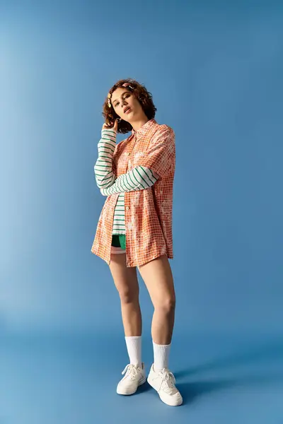 A young woman with short curly hair showcases her vibrant outfit, embodying summer style. — Stock Photo
