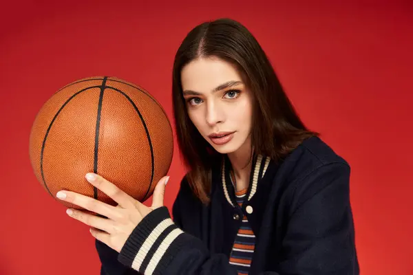 Young beautiful woman showcases fashion sense while holding basketball, embodying sporty chic vibe. — Stock Photo