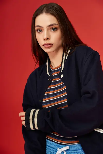 A fashionable young woman confidently poses in stylish attire that radiates vibrancy and charm. — Stock Photo