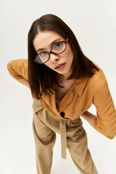 A young woman showcases her unique style while posing confidently in a chic outfit. — Stock Photo