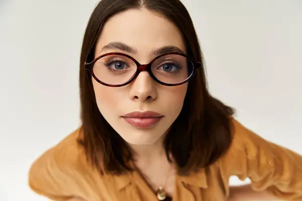 Una mujer joven muestra su estilo seguro con atuendo colorido y gafas de moda. — Stock Photo