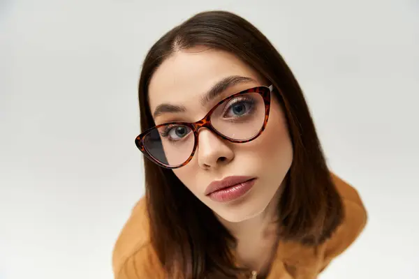 Young woman captivates with her trendy attire and stylish glasses, radiating confidence and flair. — стокове фото
