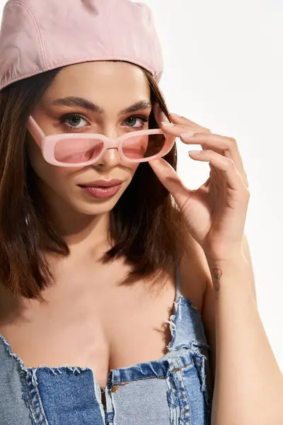 A young woman displays her chic style, wearing fashionable sunglasses and a striking outfit. — стокове фото