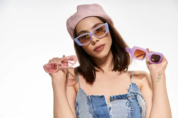 Confident young woman displays fashionable sunglasses while wearing a chic outfit under the sun — Stock Photo