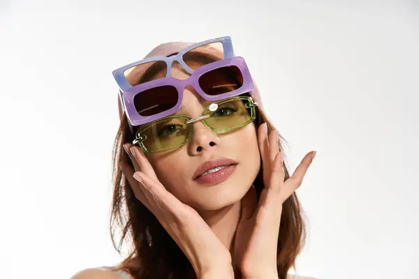 Una joven con atuendo de moda exhibe gafas de sol únicas, irradiando elegancia y estilo. - foto de stock